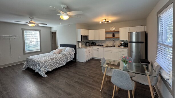 Un apartamento pequeño con un dormitorio, kitchenette y comedor.