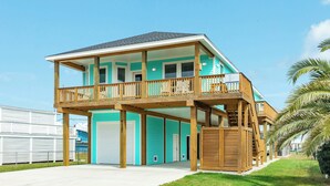 A two-story house with a balcony and a covered porch. - Teal Turtle - Sassy & Sophisticated Sea Isle Spot (Galveston)
