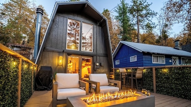 Een modern huis met terras, buitenmeubels en een vuurkorf.