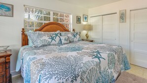 A bedroom with a bed, wooden headboard, and a nightstand with a lamp. - Clearwater Beach Home w/ Private Pool & Pool Table (Clearwater)