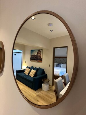 Ein modernes Wohnzimmer mit einem dunkelblauen Sofa, einem runden Couchtisch und einem Gemälde des Kolosseums.