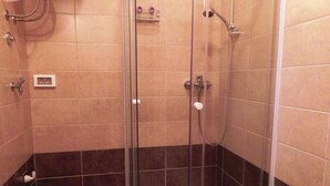 A shower with a glass door, a handheld showerhead, and a wall-mounted faucet. - One Bedroom Apartment with Terrace (Savudrija)