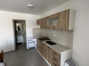 Een moderne keuken met houten kastjes, een inbouwoven en een aanrecht.