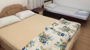 A hotel room with a large bed, a smaller bed, a nightstand, and a window with curtains. - Apartments Roza - Standard Double Room with Shared Bathroom 1 (Herceg Novi)