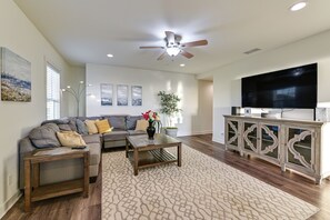 TV, fireplace, books - Stroll to Shore: Oceanside Condo w/ Hot Tub Access (Oceanside)