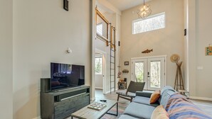 Una sala de estar moderna con televisor, sofá y mesa de centro.