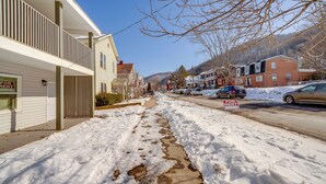 A snow-covered street with buildings on either side, a 'For Rent' sign, and a 'For Lease' sign. - Explore the Hinton Historic District! Luxe Studio (Hinton)