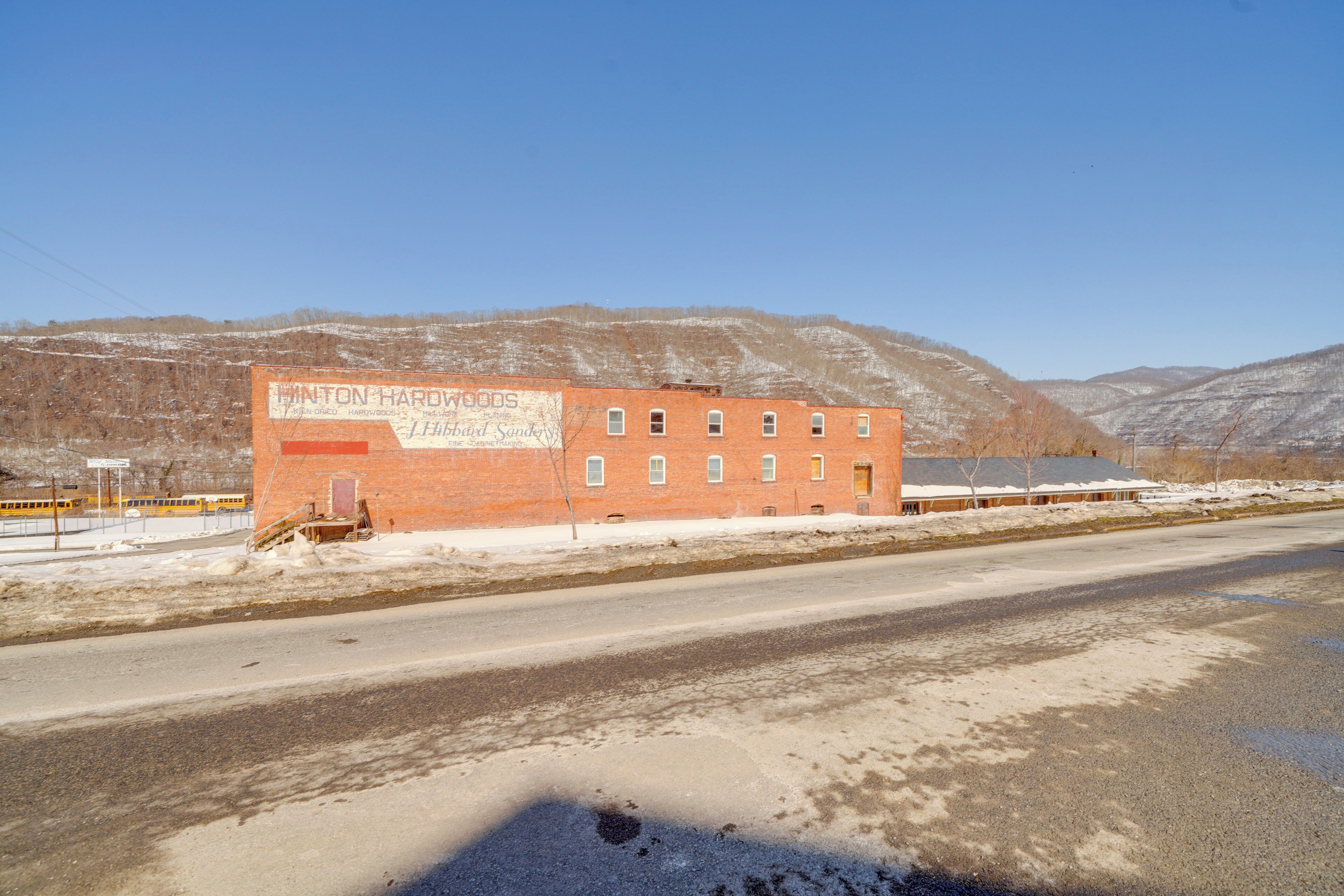 Un bâtiment en briques sur lequel on peut lire l’inscription « Hinton Hardware ».