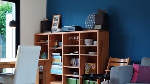 Ein Wohnzimmer mit einem Holzregal, einem grauen Sofa und einem weißen Sessel.