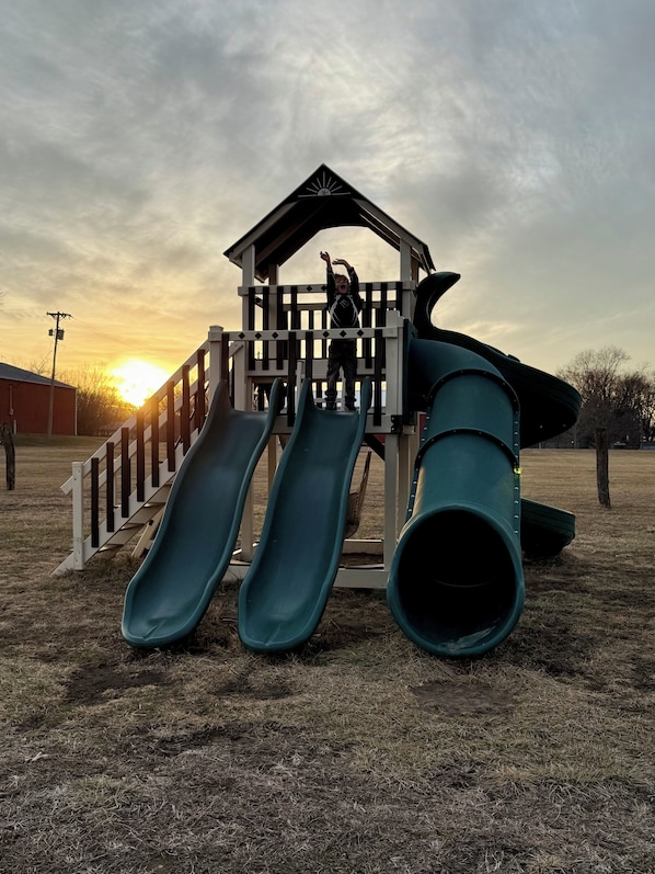 A playground with a slide and a climbing structure.