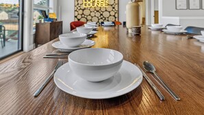 A dining table set with white bowls and plates, silverware, and a neon sign reading 'THE LUMBER LOUNGE'. - *NEW*Private Chef-Family Friendly-Beach-Arcade Games-WI Dells (New Lisbon)