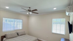 A bedroom with a bed, ceiling fan, recessed lighting, and two windows with blinds. - Modern 3BR LA Home near Downtown LA, Perfect for Families and Large Groups (Los Angeles)
