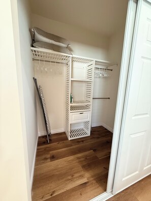 A walk-in closet with open shelving, a hanging rod, and a shoe rack.