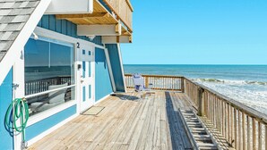 A wooden deck with a view of the ocean, a door labeled '2', and a chair on the deck. - Iconic A Frame Directly Over The Surfside Waves (Surfside Beach)