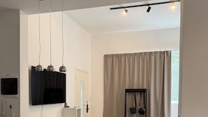 Una cocina moderna con encimera de granito, horno empotrado y lámpara colgante negra.