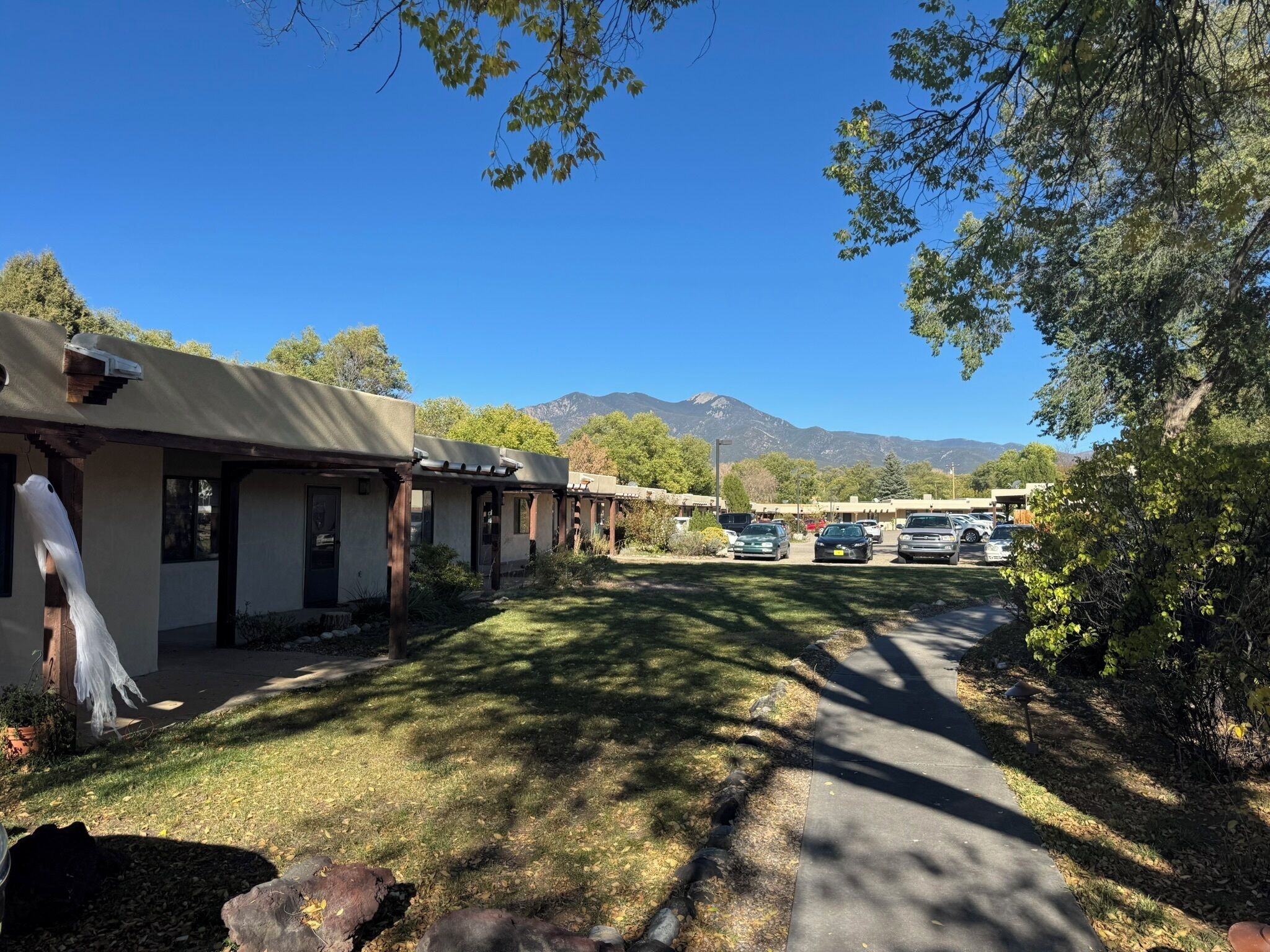 Une rangée de chambres de motel avec une vue sur les montagnes en arrière-plan.