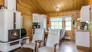 A cozy cabin interior with a fireplace, dining area, and kitchen. - Kuikkaranta by Interhome (Juuka)