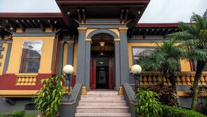 A building with a grand entrance, a staircase, and potted plants. - Hotel in San Jose Hotel Majestad (San Jose)