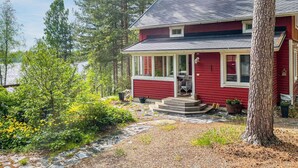 A red house with a porch, a chimney, and a view of a lake. - Vacation home Metsis by Interhome (Nurmes)