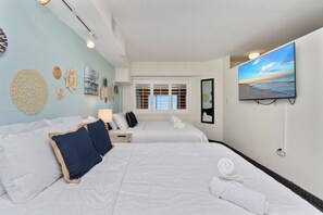 A hotel room with two beds, a TV, a window with blinds, and wall decor. - Newly Renovated 8th-Floor Oceanfront Condo @ Beach Cove! Heated Pools, Sleeps 6 (North Myrtle Beach)