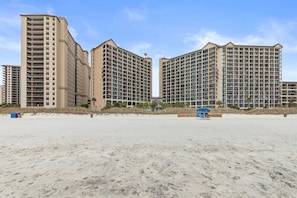 Ein Strandhotel mit mehreren Hochhäusern, einem Sandstrand und einer Rettungswache.