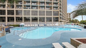 A hotel with a large outdoor swimming pool, multiple balconies, and sun loungers. - Oceanfront, Pools, Lazy River @ Beach Cove Resort (North Myrtle Beach)