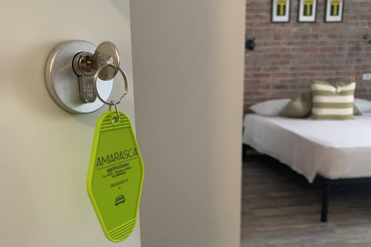 A keychain with 'AMARASCA' and contact details hanging on a door handle.