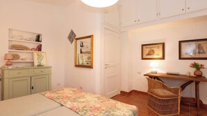 A bedroom with a bed, a desk, a chair, and a wardrobe. - Villa Gioia | Tranquil Hideaway Beach Cottage (Pula)
