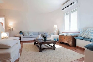 Una sala de estar con un sofá, una mesa de centro y una lámpara.