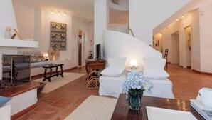 A modern living room with a white sofa, a wooden coffee table, and a decorative vase. - Villa Gioia | Tranquil Hideaway Beach Cottage (Pula)