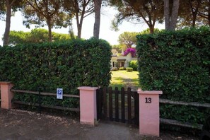 A gated entrance with a number sign, a parking sign, and a well-maintained hedge. - Villa Gioia | Tranquil Hideaway Beach Cottage (Pula)