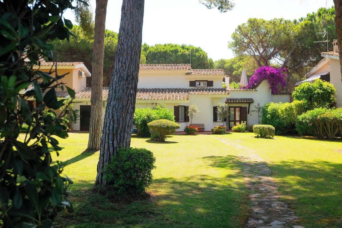 Une villa dotée d’un toit en tuiles, d’un chemin en pierre et de jardins bien entretenus.