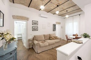 Un salon moderne comprenant un canapé, une table à manger et un coin cuisine.