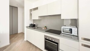 A modern kitchen with white cabinetry, a built-in microwave, and a stainless steel oven. - Casa di Miranda by Trastevere (Rome)