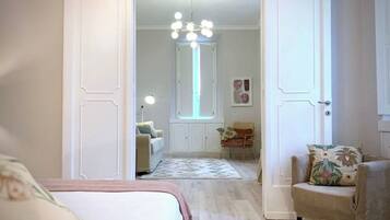 A bedroom with a bed, a chair, a desk, and a window.