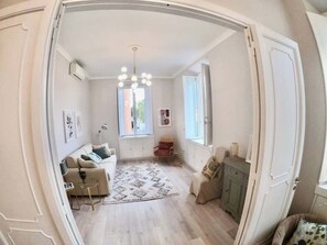 A room with a sofa, a chair, a rug, a cabinet, and a window. - Casa Cavalleggeri by St. Peter's Square (Rome)