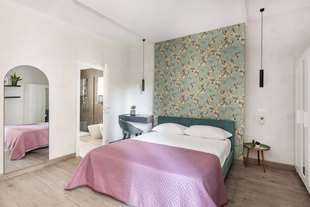Ein modernes Schlafzimmer mit Bett, Schreibtisch und Dusche.
