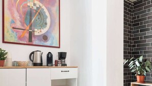 A modern kitchen with a white cabinet, a coffee maker, and a kettle. - Aria di Trastevere | Double Bedroom "2" en suite (Rome)