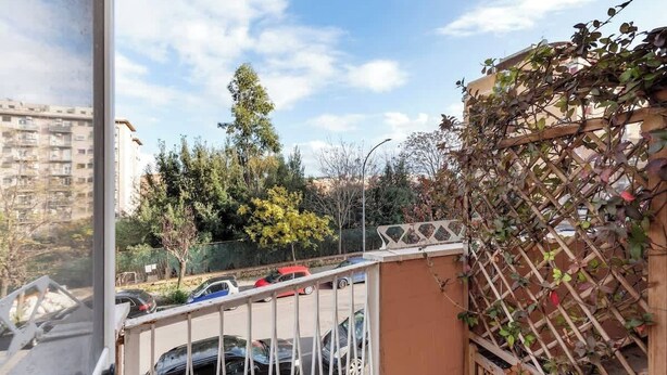 A balcony with a view of parked cars and a building in the background. - Street Art Roma | 3BR apartment | Near Tiburtina (Rome)
