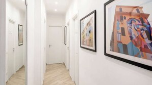 A hallway with framed artworks on the walls and a door at the end. - Street Art Roma | 3BR apartment | Near Tiburtina (Rome)