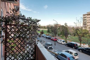 A residential street with parked cars, a clear sky, and buildings in the background. - Street Art Roma | 3BR apartment | Near Tiburtina (Rome)
