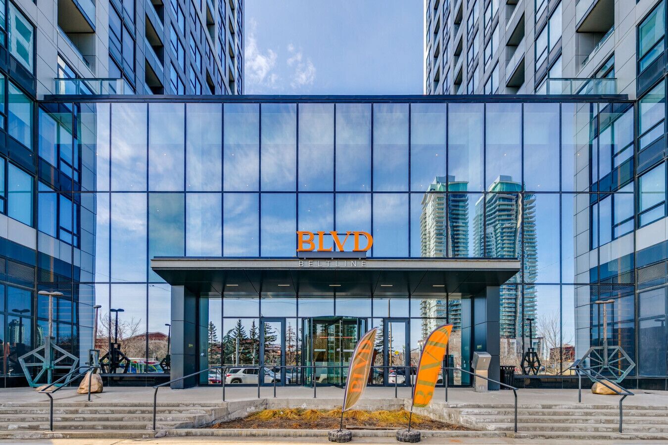 Een modern gebouw met een glazen gevel, met de naam 'BLYD' duidelijk zichtbaar boven de ingang, en een trap die naar de ingang leidt.