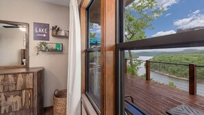Ein Zimmer mit Seeblick, einer Holzterrasse und einem Schild, das den Weg zum See weist.