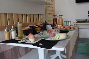 Ein Frühstücksbuffet mit verschiedenen Speisen, Beilagen und einer Kaffeestation.