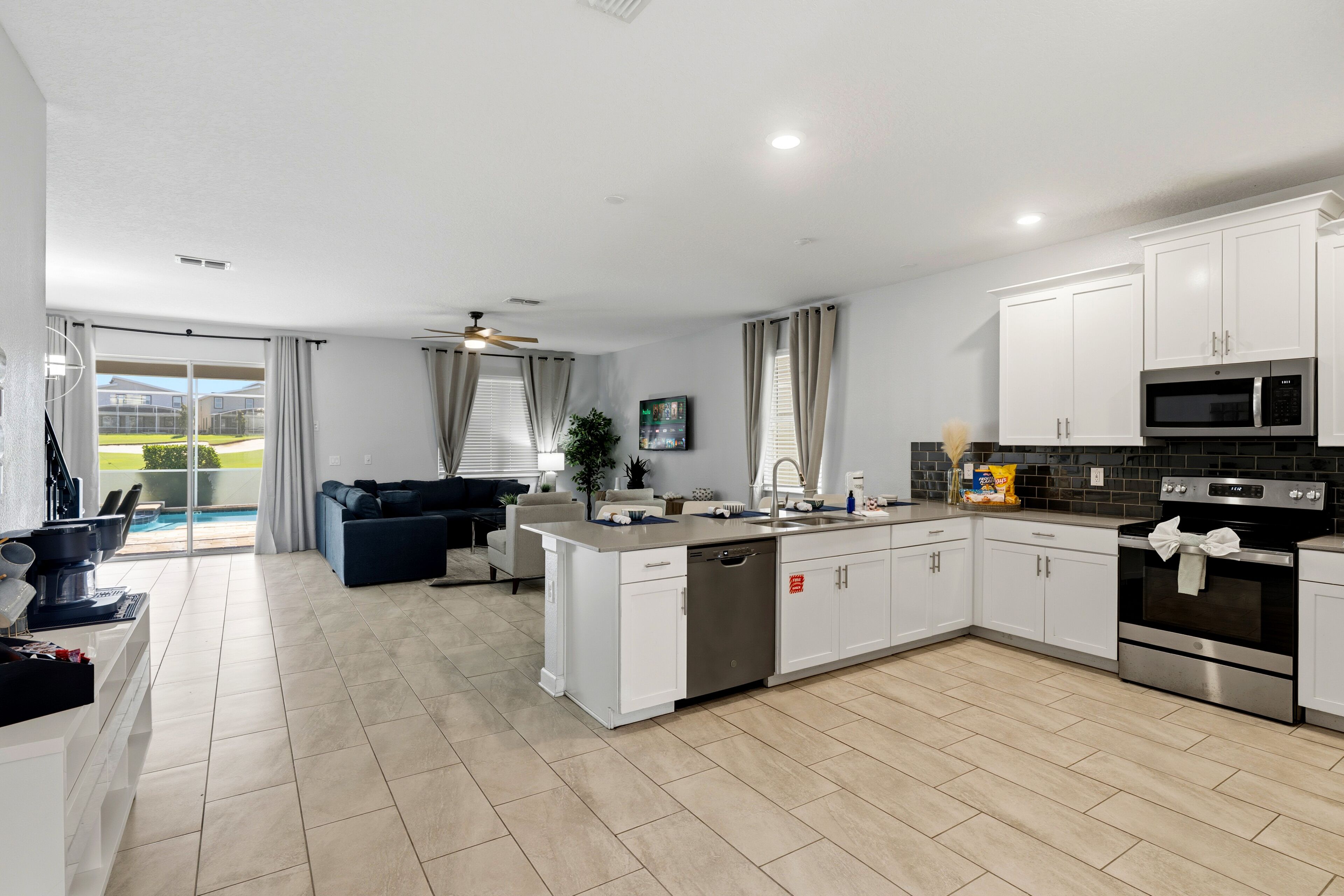 A modern kitchen with white cabinets, a dishwasher, a microwave, and an oven.
