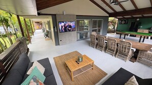 A covered outdoor lounge area with a sofa, chairs, a coffee table, and a pool table. - Cowan Lodge Cowan Cowan (Cowan Cowan)