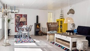 A cozy living room with a fireplace, a dining area with a glass table, and a sofa.