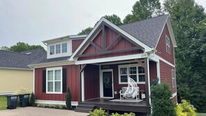 A two-story house with a front porch, a mailbox, and a driveway.
