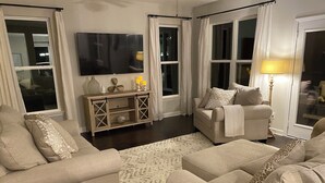 A living room with two sofas, a TV, a side table, and a lamp.