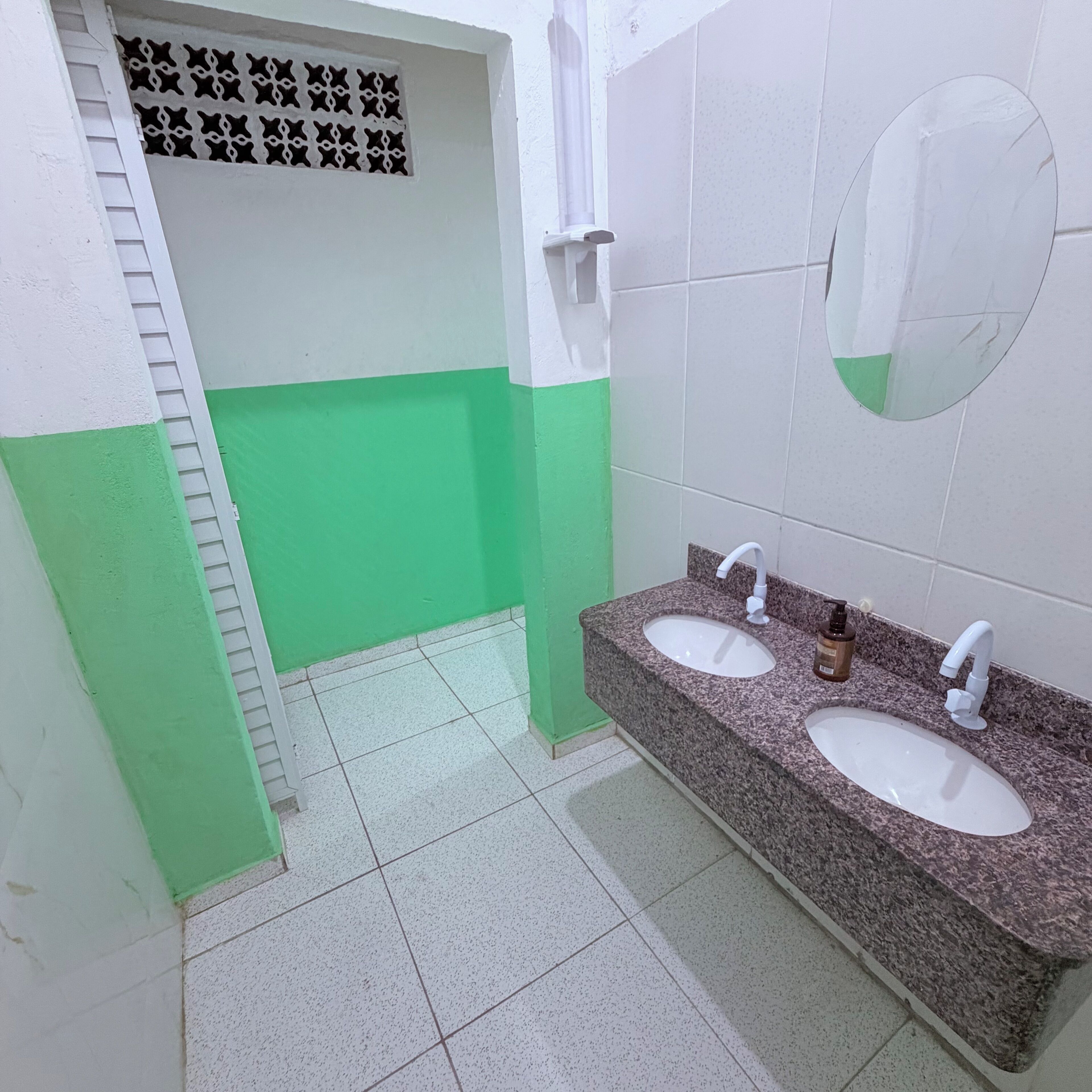 Ein Badezimmer mit zwei Waschbecken, einem Spiegel und einem Fenster mit einem stjärnen Vorhang.